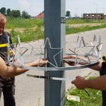 Dwa robotnicy instalujący metalowe komponenty oświetlenia - komponenty elektryczne i oświetlenie Polamp.