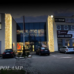 Budynek handlowy w nocy, podświetlone kolumny - komponenty elektryczne i oświetlenie Polamp.