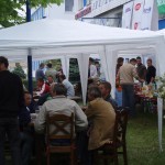 Namiot na zewnątrz z ludźmi przy stołach - komponenty elektryczne i oświetlenie Polamp.