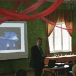 Mężczyzna w garniturze stojący przed wyświetlanym obrazem - komponenty elektryczne i oświetlenie Polamp