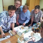 Ludzie pracujący przy stole - komponenty elektryczne i oświetlenie Polamp