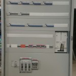 Szary panel kontrolny z przełącznikami i lampkami - komponenty elektryczne i oświetlenie Polamp.